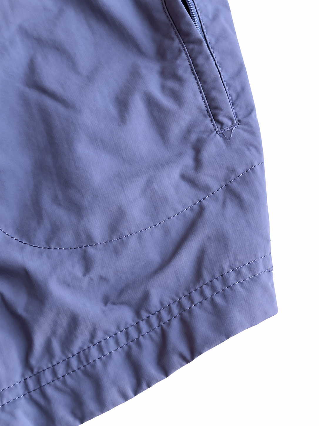Nike-Swoosh und helle Paspeln der violetten Jacke